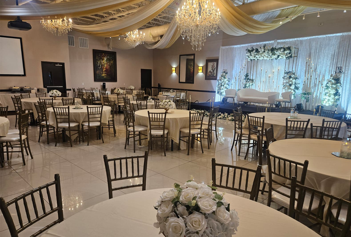 Elegant reception ballroom with chandeliers and a floral backdrop at Signature Cuisine