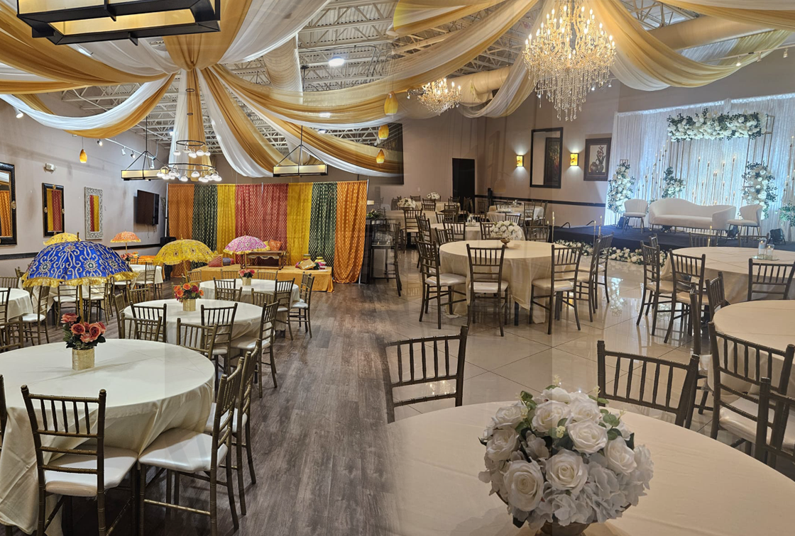 Banquet hall set for a celebration with draped ceiling and festive decor at Signature Cuisine